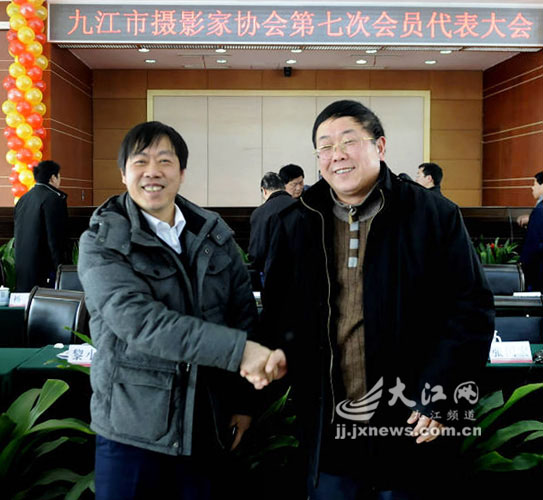 新当选主席宋小勇(左)与第六届理事会主席洪世坤亲切握手